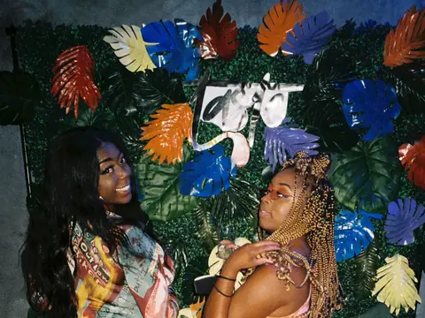Guests in front of a floral photo backdrop at a themed night at The Catwalk Club (Sat 11 June)
