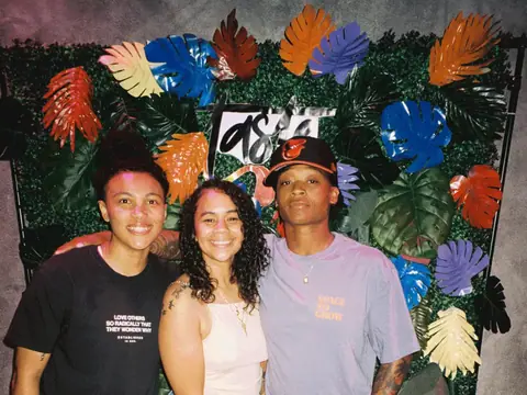 Guests in front of a floral photo backdrop at a themed night at The Catwalk Club (Sat 11 June)